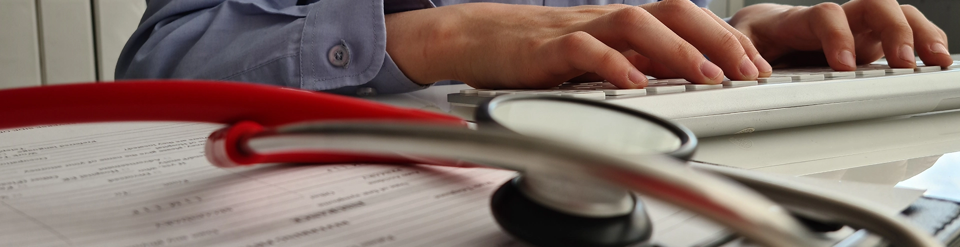 Stethoscope resting on a keyboard in a medical clinic, symbolizing doctor's workspace.